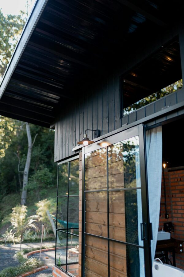 Chic modern house with glass and wood panels against lush greenery.